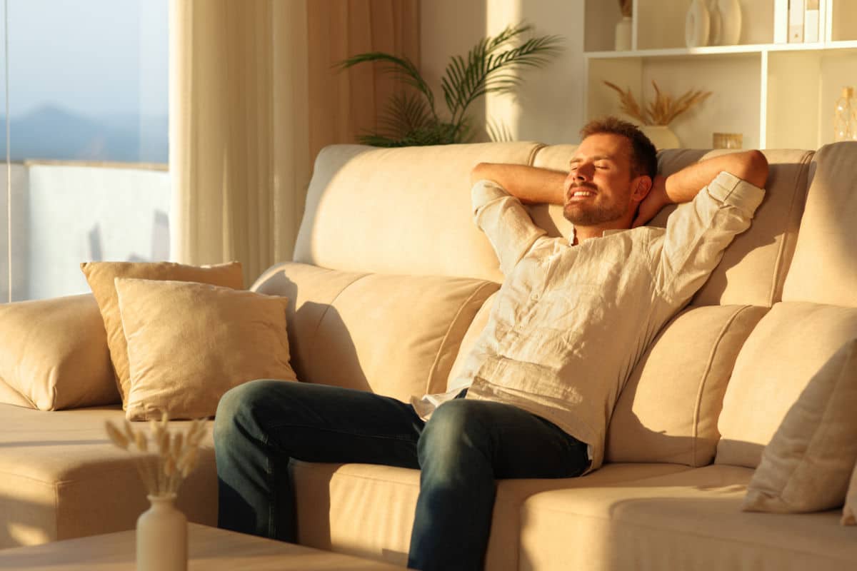 Happy,Man,Relaxing,Sitting,On,A,Comfortable,Couch,At,Sunset